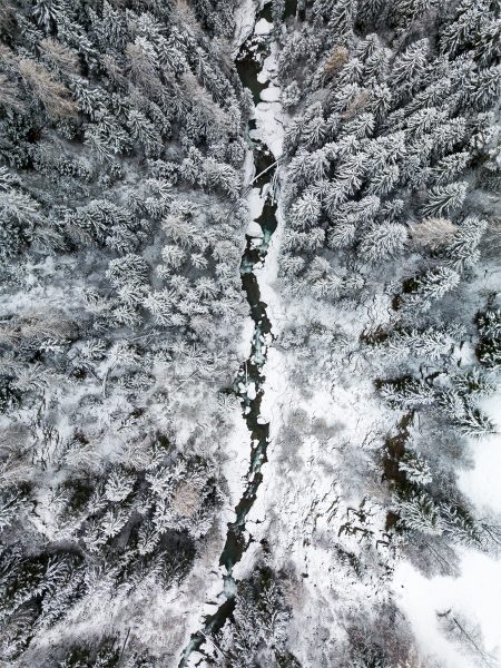 switzerland-roadtrip-river-drone-forest-winter-snow